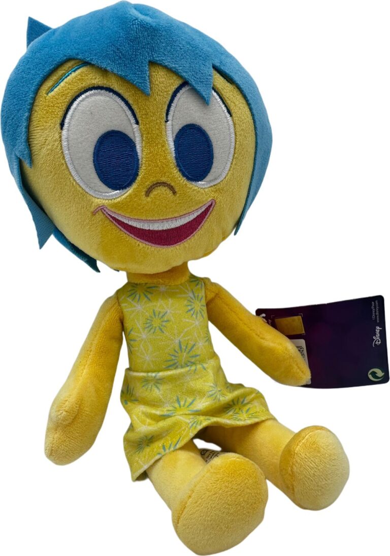 Gelbes Plüschtier mit blauen Haaren und blumigem Kleid, seitlich sitzend. Gelbes Plüschtier mit blauen Haaren und blumigem Kleid, seitlich sitzend.